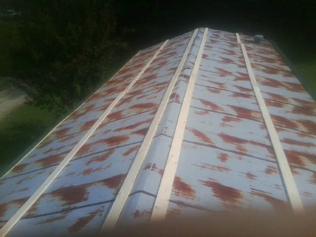 Rusted metal roof panels with new wood purlins before replacement — Storm Damage Roof Repair in Gates Mills by Roofing Brothers