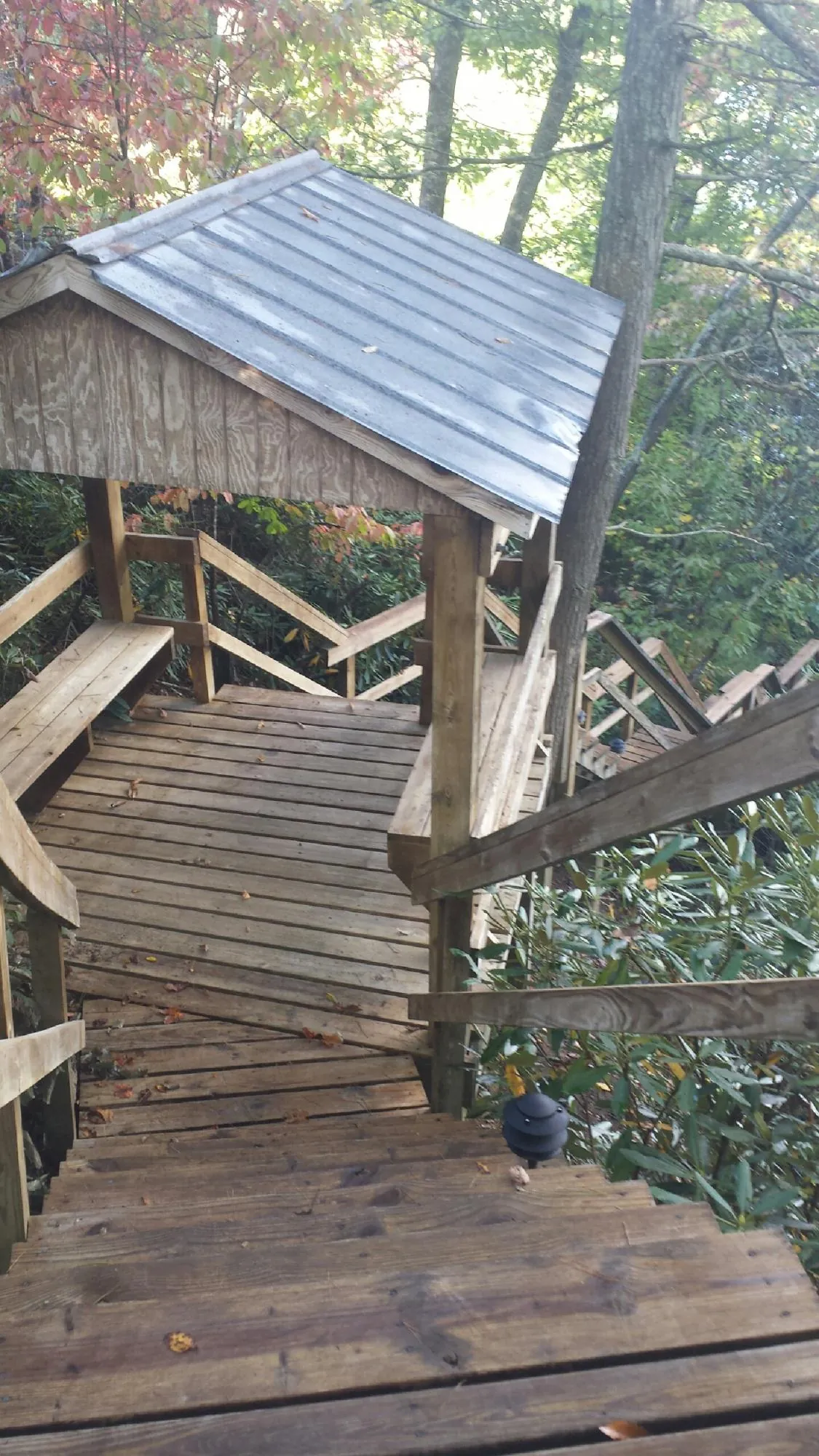 Metal roofed shelter over wooden steps on a wooded walkway — Skylight Repair & Installation work by our crew in Gates Mills