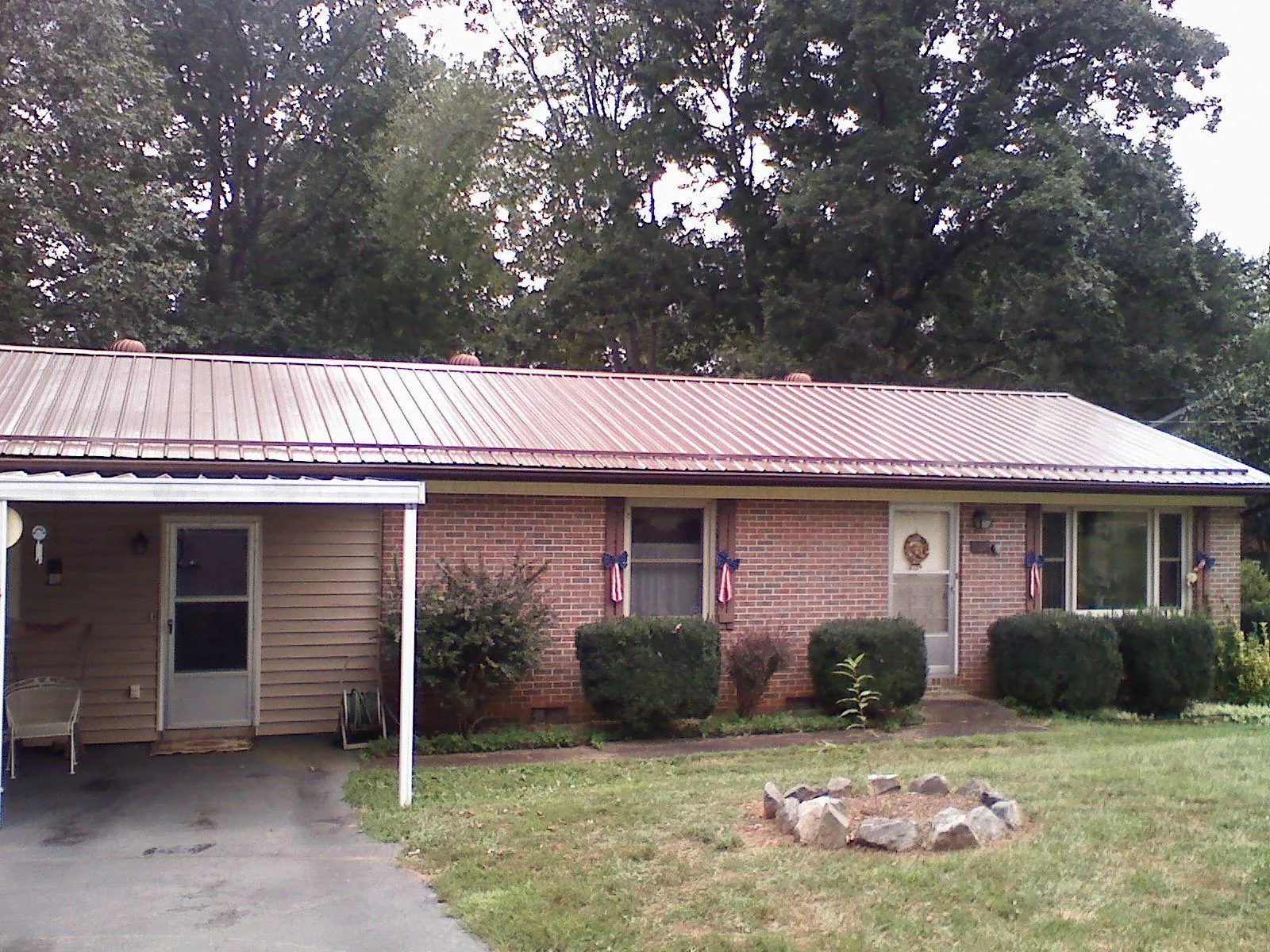 Bronze metal roof and carport on a brick ranch home — Roof Repair work by our crew in Gates Mills
